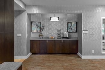 a lobby with a counter with a coffee maker and a sink at The Pointe at St. Joseph Apartments, South Bend, IN, 46617